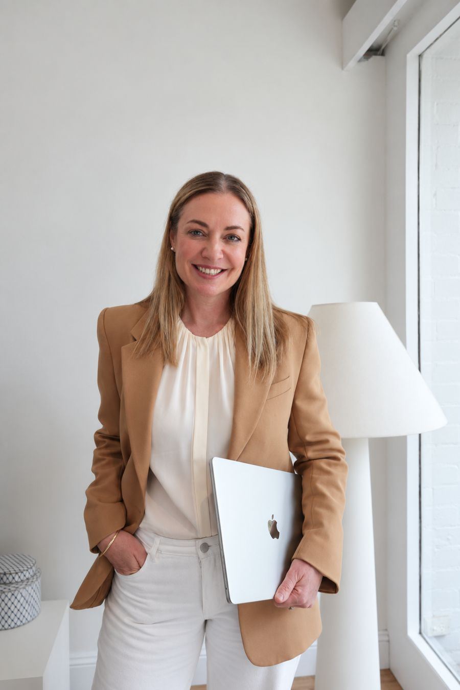 Nicole Darragh holding a laptop in a light-filled room
