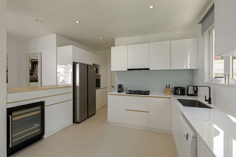 The renovated kitchen, with white cabinetry and light oak details